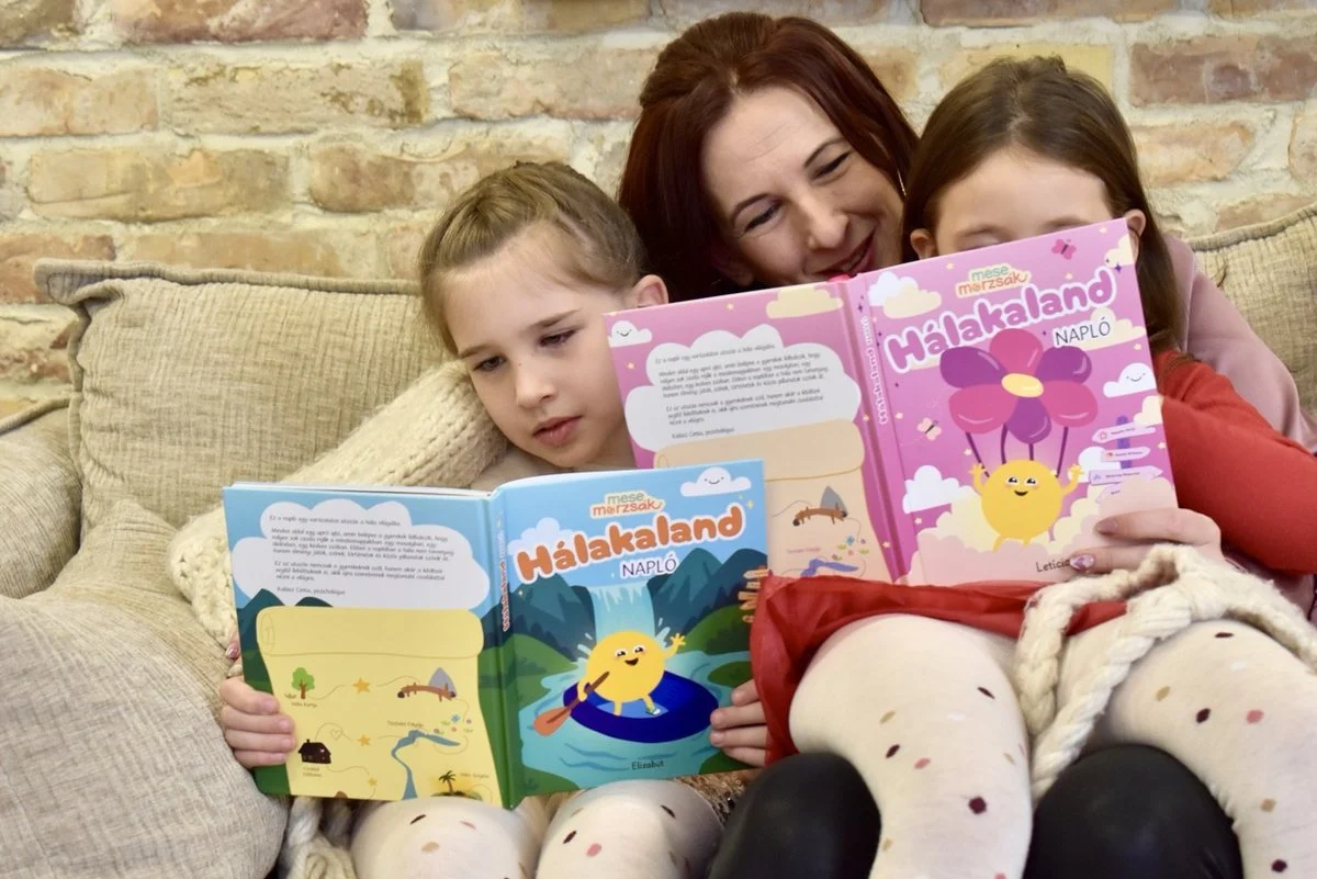 Anya és két gyerek a kanapén, kezükben a Hálakaland Napló