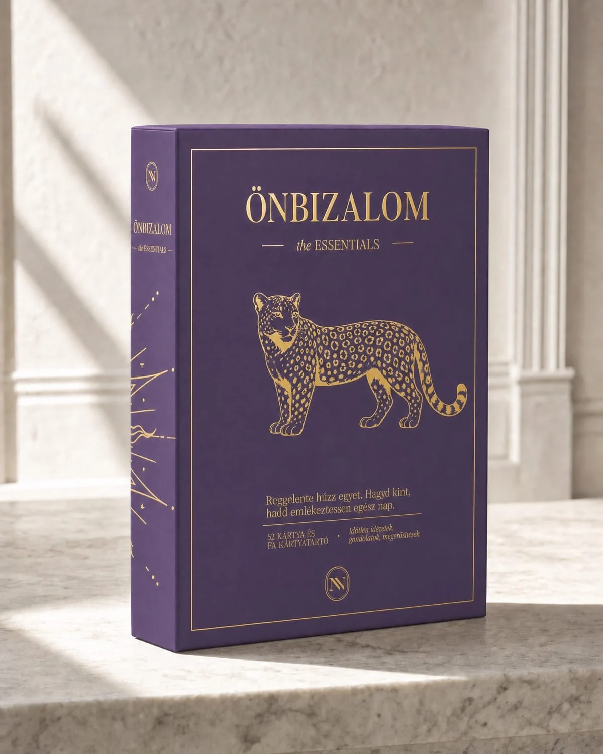 ÖNBIZALOM the ESSENTIALS doboz márványon, a gerincen aranyfóliás leopárdmotívummal